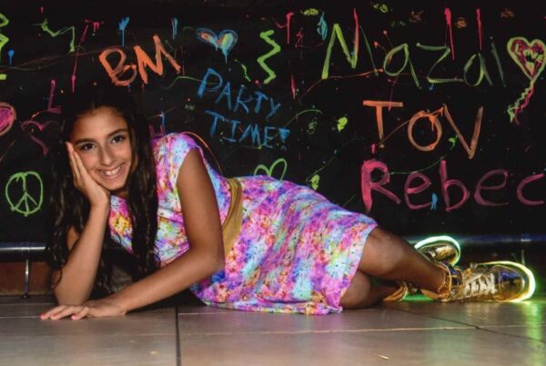 Smiling teenage girl laying on the floor propping her head up with her hand