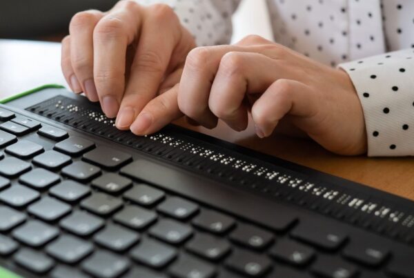 Hands typing on a braille keyboard