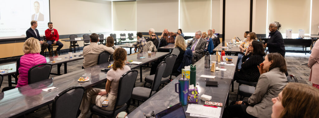 Wide angle of the room during the Dr Q&A with Drs Capone and Trese at the front of the room and a large audience listening attentively in a university room.