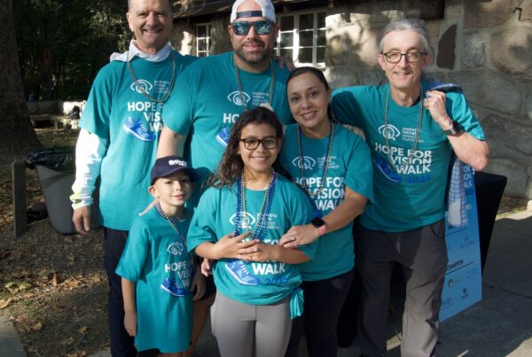 Six individuals pose together wearing matching Hope for Vision T-Shirts as part of Team Dobin.